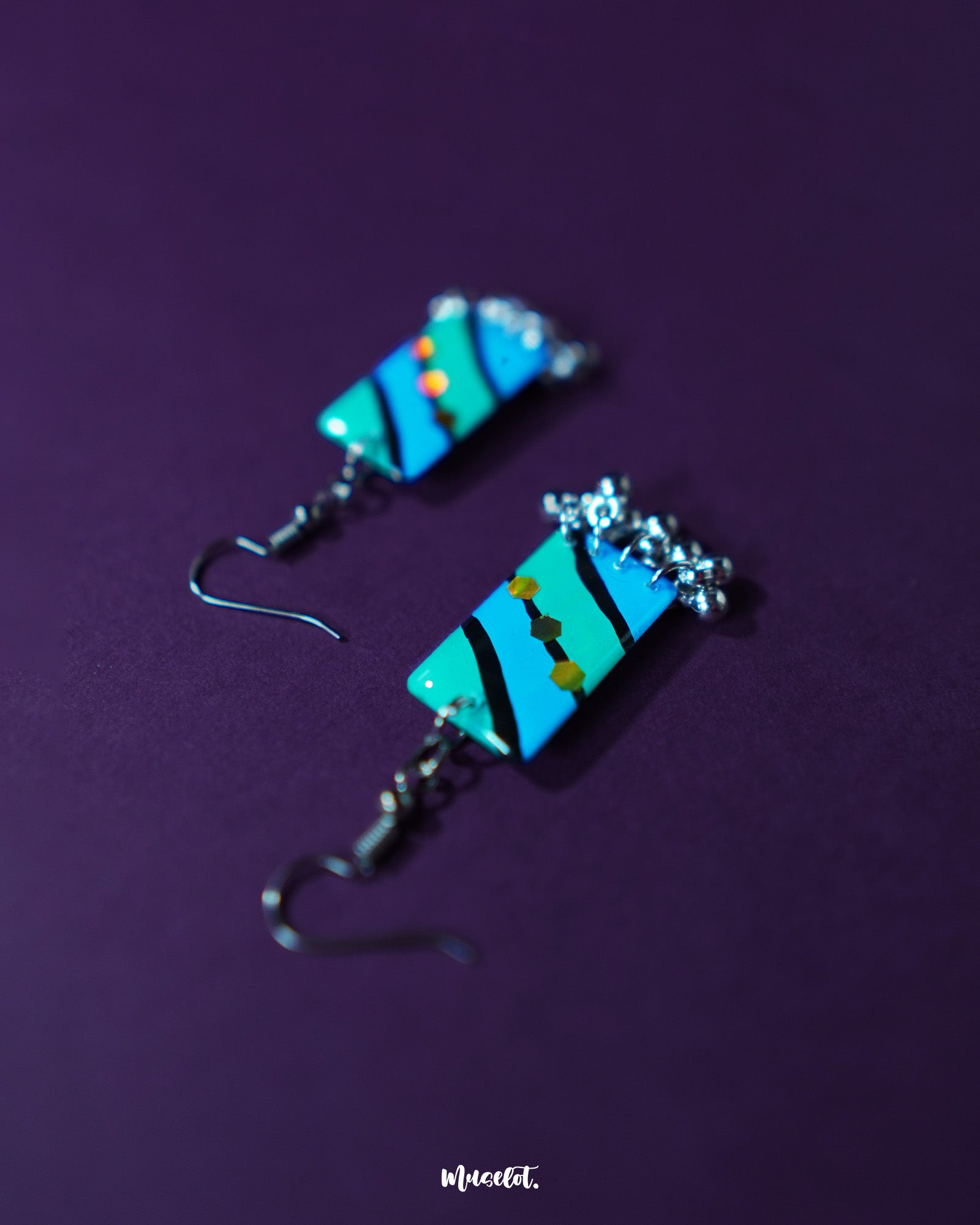 Jaltarang handmade strip hook earrings placed on a textured neutral surface, highlighting the gentle curves and balanced design of the vertical strips with an artisanal charm — Muselot.
