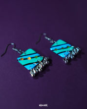 Jaltarang square strip earrings, highlighting the structured square studs and fluid metallic drops that dangle gracefully, adding a touch of bold elegance to her look — Muselot.
