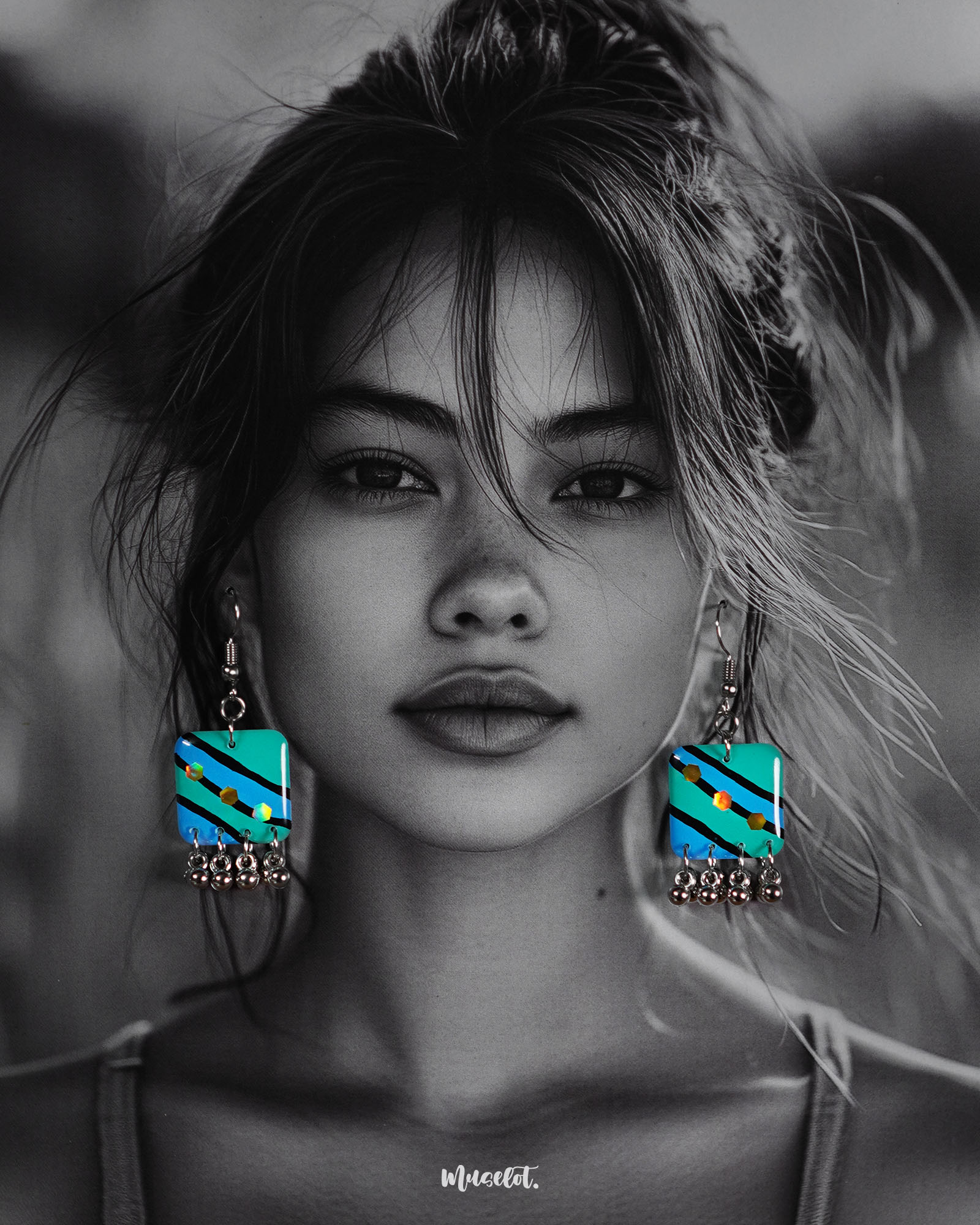 A woman models the Jaltarang strip drop earrings, featuring vertical blue and green hand-painted enamel strips with delicate silver ghungroos swaying at the ends, creating a playful yet elegant statement—Muselot.