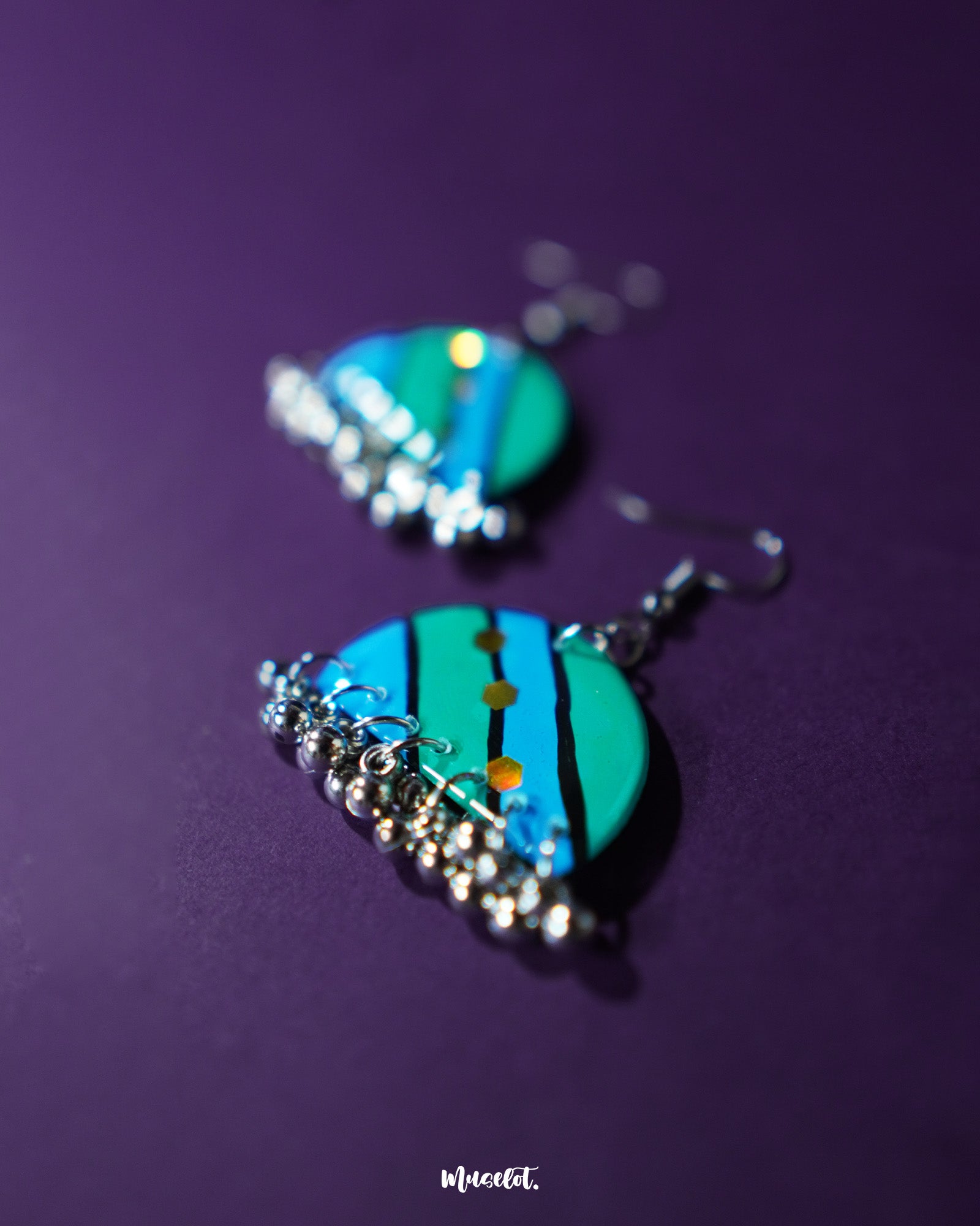A pair of Jaltarang strip earrings laid flat, highlighting their sleek metallic finish and wave-inspired drop design that exudes minimal charm—Muselot.