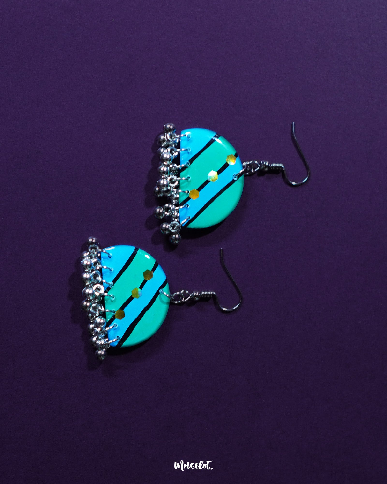 A pair of Jaltarang strip earrings rests gracefully against a muted backdrop, showcasing their sleek vertical design and artisanal finish, perfect for adding a touch of understated charm—Muselot.