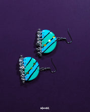 A pair of Jaltarang strip earrings rests gracefully against a muted backdrop, showcasing their sleek vertical design and artisanal finish, perfect for adding a touch of understated charm—Muselot.