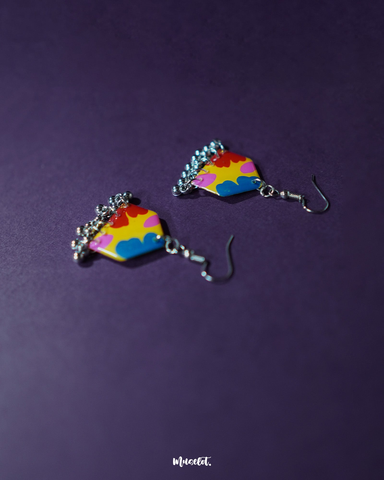 Jharokhe multicolor floral hook earrings displayed at an angle, highlighting the layered floral motifs in vivid hues and the intricate ghungroo accents that add movement and festive flair — Muselot.