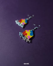Jharokhe multicolor floral hook earrings displayed upright on a soft purple background, showcasing their handcrafted detailing, vibrant floral motifs, and metallic finish that adds a festive and artistic flair — Muselot.