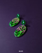 A close-up shot of the Kalibaan drop earrings, focusing on the detailed floral design and oxidized metal texture. The image highlights the bold color palette and handcrafted elegance — Muselot.