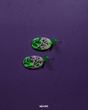 A detailed view of the Kalibaan drop earrings laid out on a soft neutral surface, showcasing their bold oxidized finish, intricate floral motif, and handcrafted charm that stands out effortlessly — Muselot.
