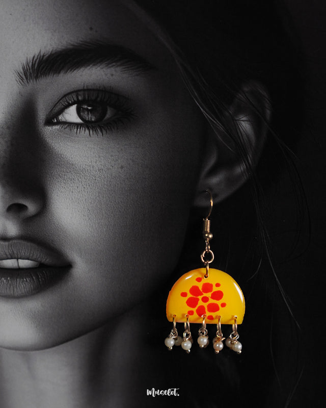 Close-up shot of a model wearing Kesarika floral earrings, adorned with intricate floral detailing and warm earthy tones that enhance the overall elegance with a touch of ethnic grace — Muselot.