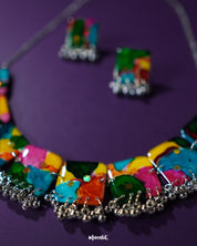 Zoomed-in view of the colorful jewelry set from Muselot, laid against a rich purple background. The vibrant mix of multicolored beads and playful design elements are in sharp focus, highlighting the lively boho spirit and handcrafted artistry — Muselot.