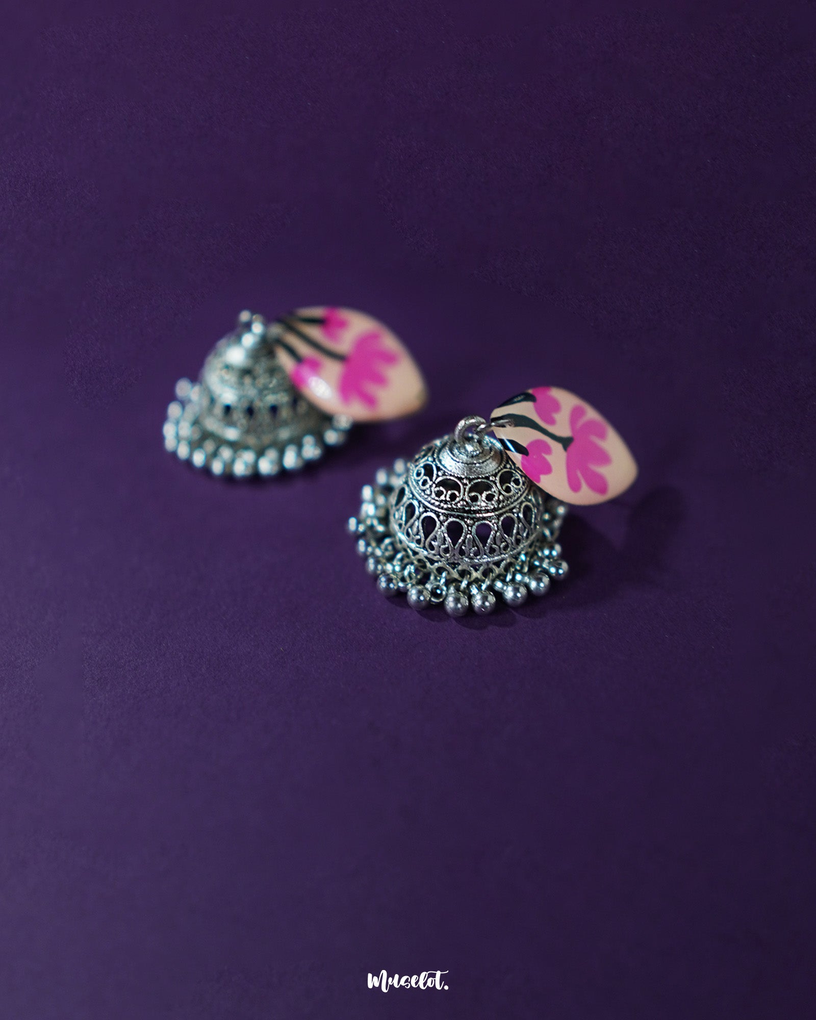 Side angle of Kumudini pink lotus jhumkas, highlighting the layered petal motif and handcrafted detailing with a neutral backdrop – Muselot.