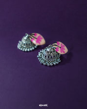 Side angle of Kumudini pink lotus jhumkas, highlighting the layered petal motif and handcrafted detailing with a neutral backdrop – Muselot.