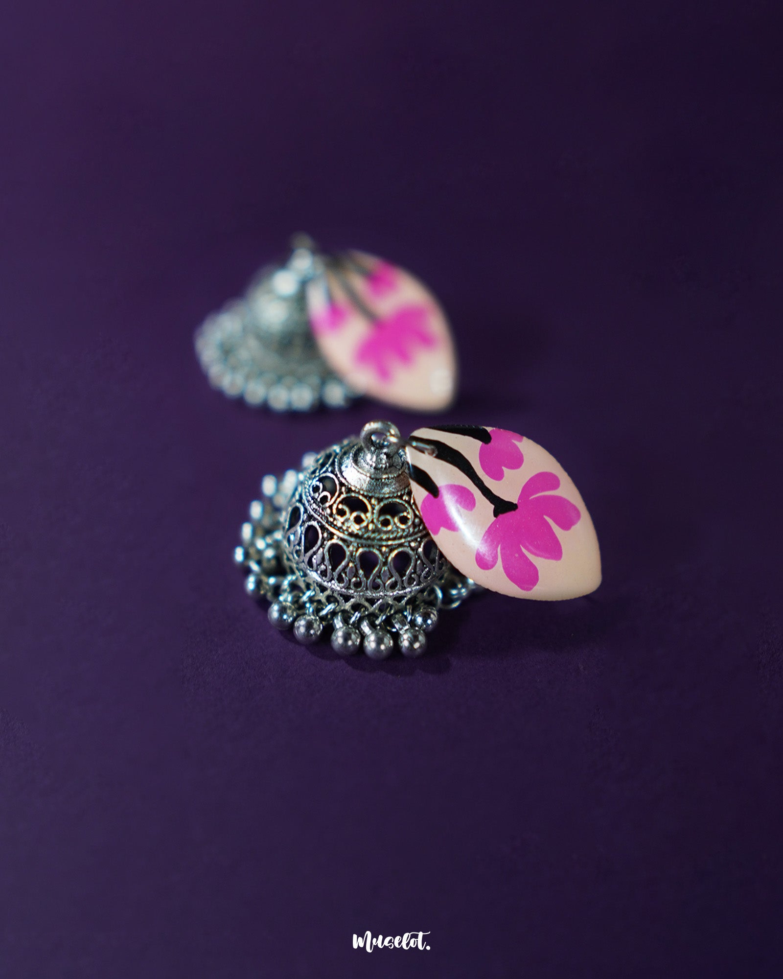 Close view of Kumudini pink lotus jhumkas, emphasizing the lotus bloom design and intricate enamel work against a plain background – Muselot.