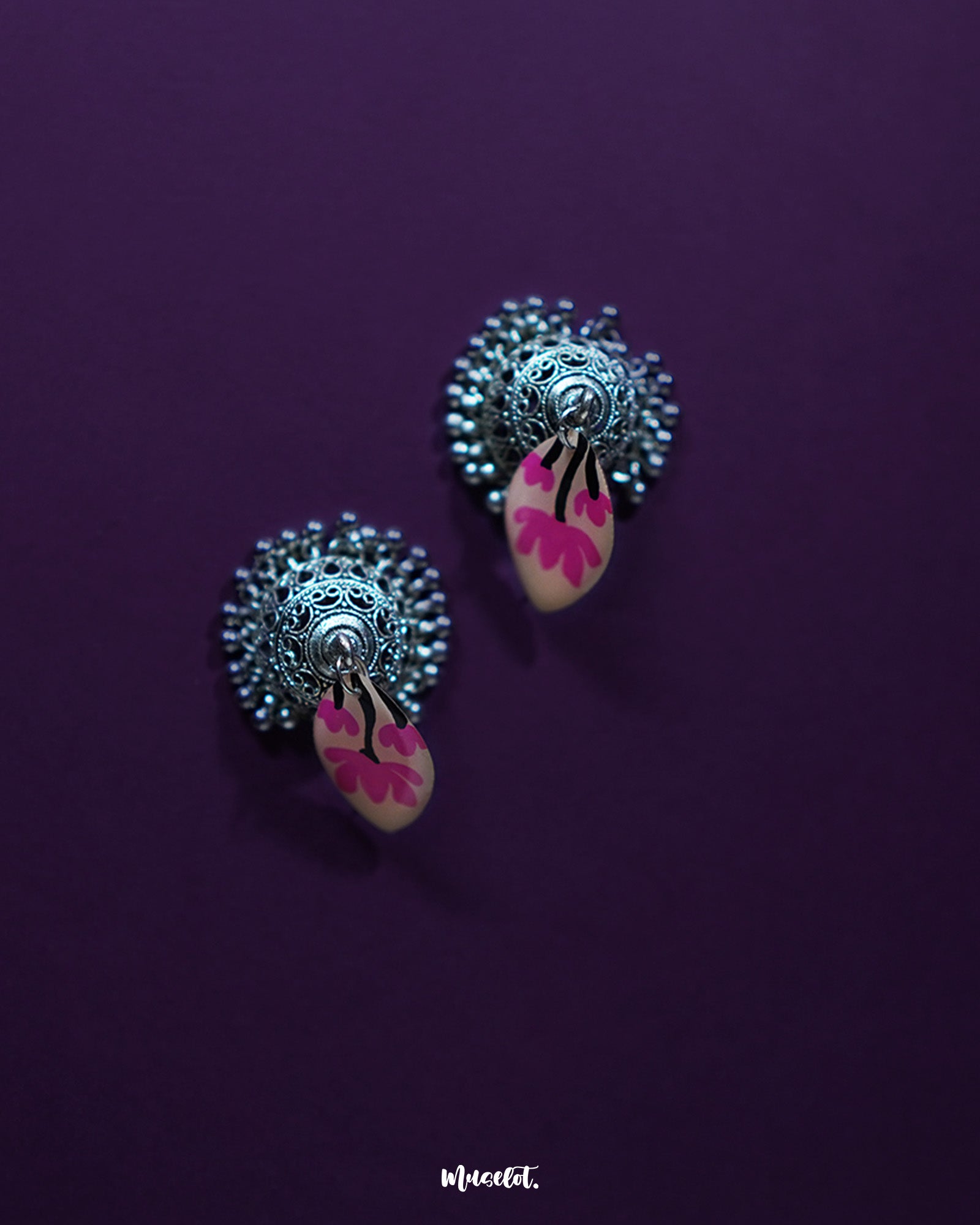 Artistic shot of Kumudini pink lotus jhumkas, capturing the lotus motif and intricate metalwork with a clean background – Muselot.