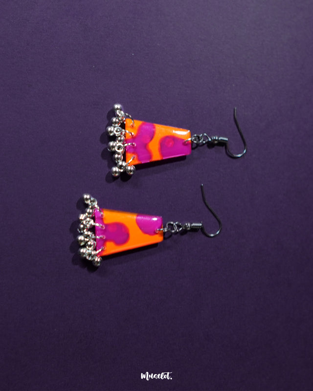 Laalsavera earrings set against a deep purple backdrop, bring out a harmonious blend of traditional essence and contemporary style. The intricate detailing and vibrant hues make them a stunning pick for statement-making moments – Muselot