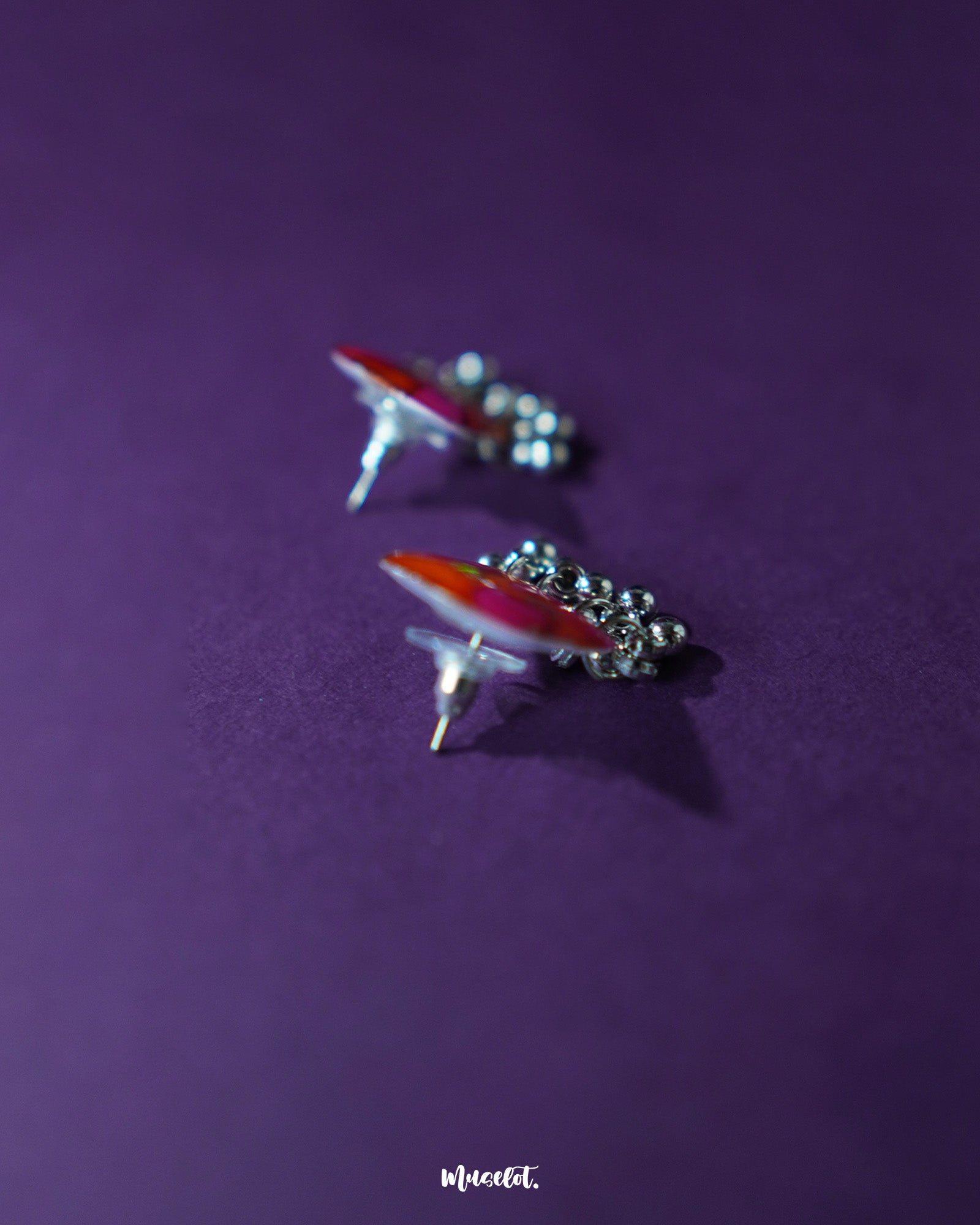 The Laalsavera stud earrings, delicately crafted and highlighted against a rich purple backdrop, bring a touch of sophistication — Muselot.