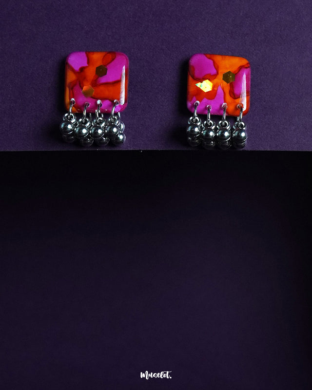 Laalsavera stud earrings resting on a soft purple background, highlighting their minimal yet striking design that adds a touch of contemporary charm to your collection – Muselot