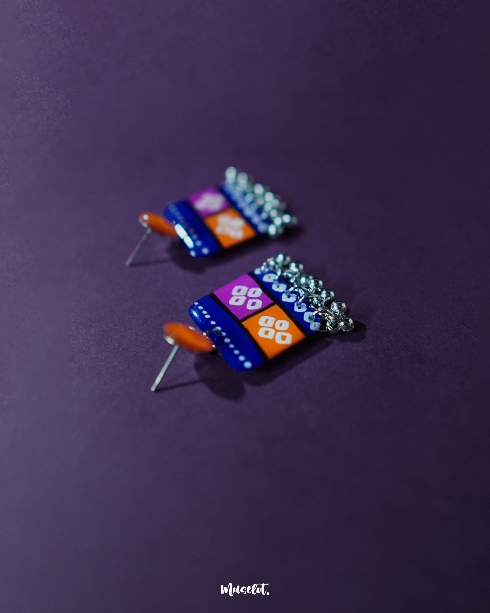 Leheriya traditional art drop earrings with bright orange round studs attached to blue rectangular drops featuring orange and magenta blocks, decorated with white geometric patterns and dotted detailing, finished with dangling silver beads, beautifully displayed to showcase their vibrant handcrafted charm – Muselot.