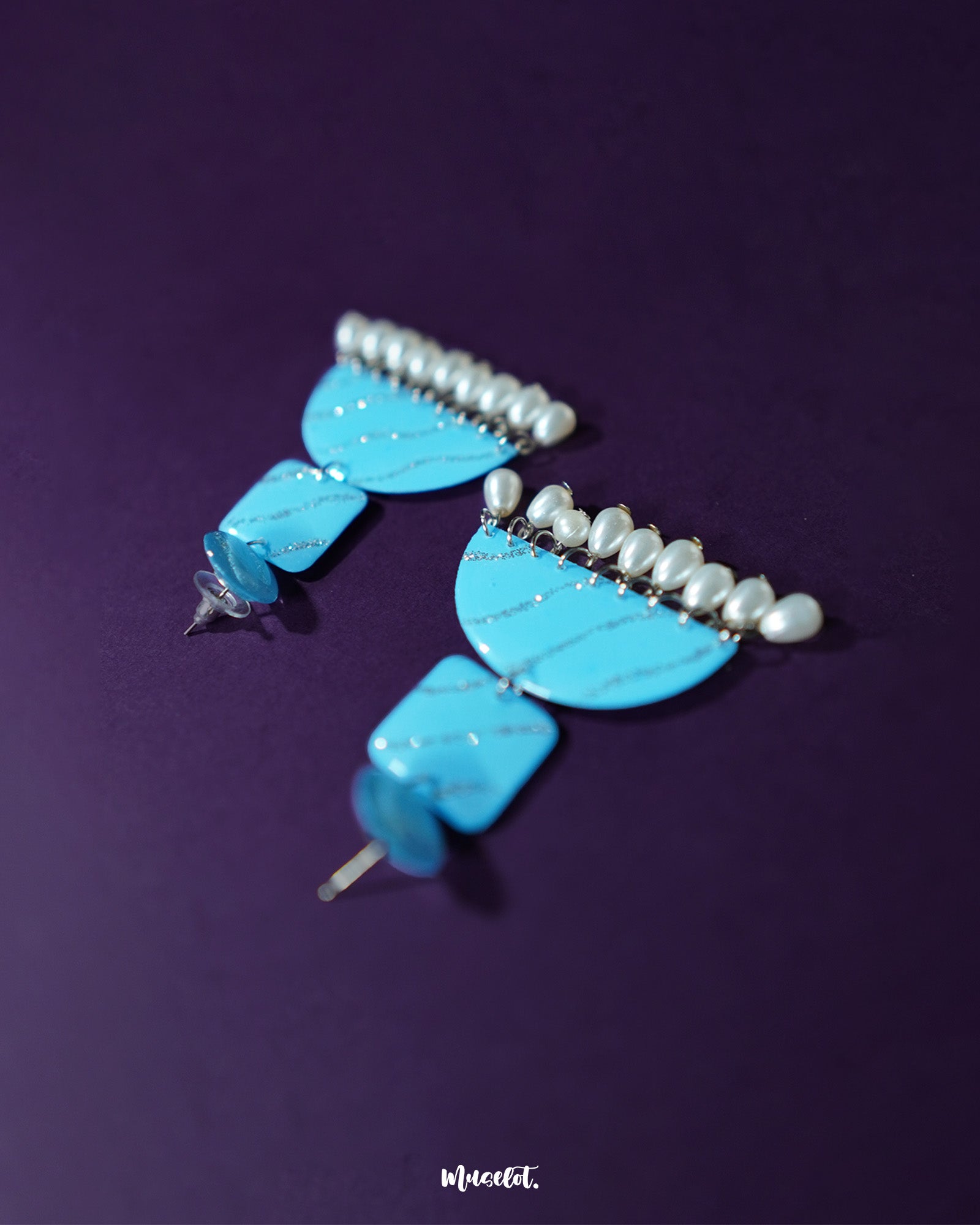 A close-up view of the Lehrbaan blue pearl jhumkas, highlighting the shimmering pearl cluster and ornate gold-toned dome — Muselot.