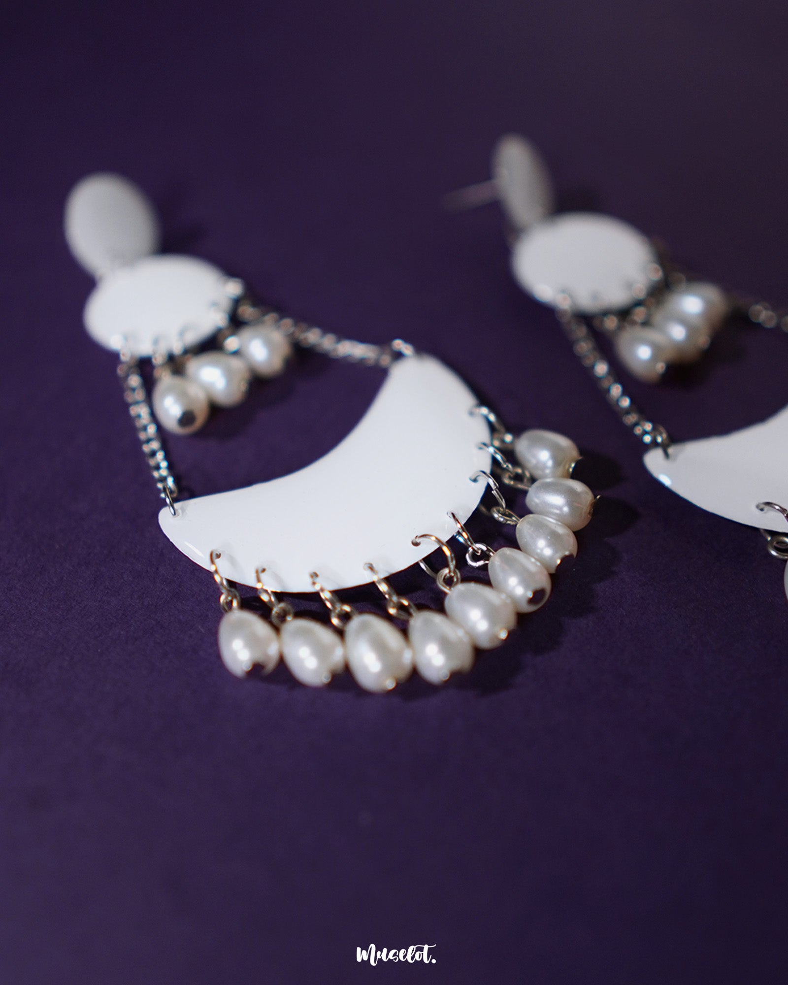 Mahtab pearl chandbali earrings set against a purple background, highlighting the white crescent base adorned with dangling silver chains and lustrous teardrop pearls, showcasing graceful craftsmanship — Muselot.