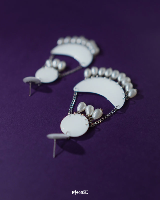 A close-up of the Mahtab pearl chandbali earrings showcasing their crescent silhouette with intricate white enamel detailing and delicate pearl drops, highlighting elegance and fine craftsmanship — Muselot.
