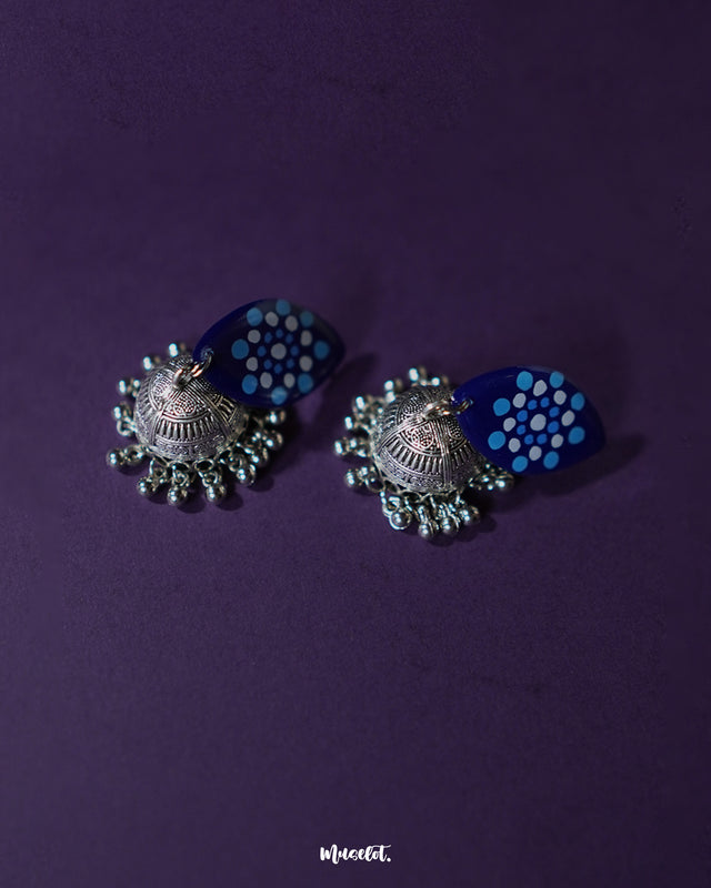 Meghmalhar boho jhumkas featuring oxidized silver dome-shaped charms paired with navy blue marquise tops hand-painted with sky blue and white dotted mandala patterns, showcasing artistic flair and highlighting traditional charm with a contemporary twist — Muselot.