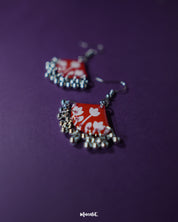 Close-up of Meherbaan red floral hook earrings featuring intricately layered flower petals and tiny hanging beads, highlighting handcrafted finesse and showcasing their statement charm — Muselot.