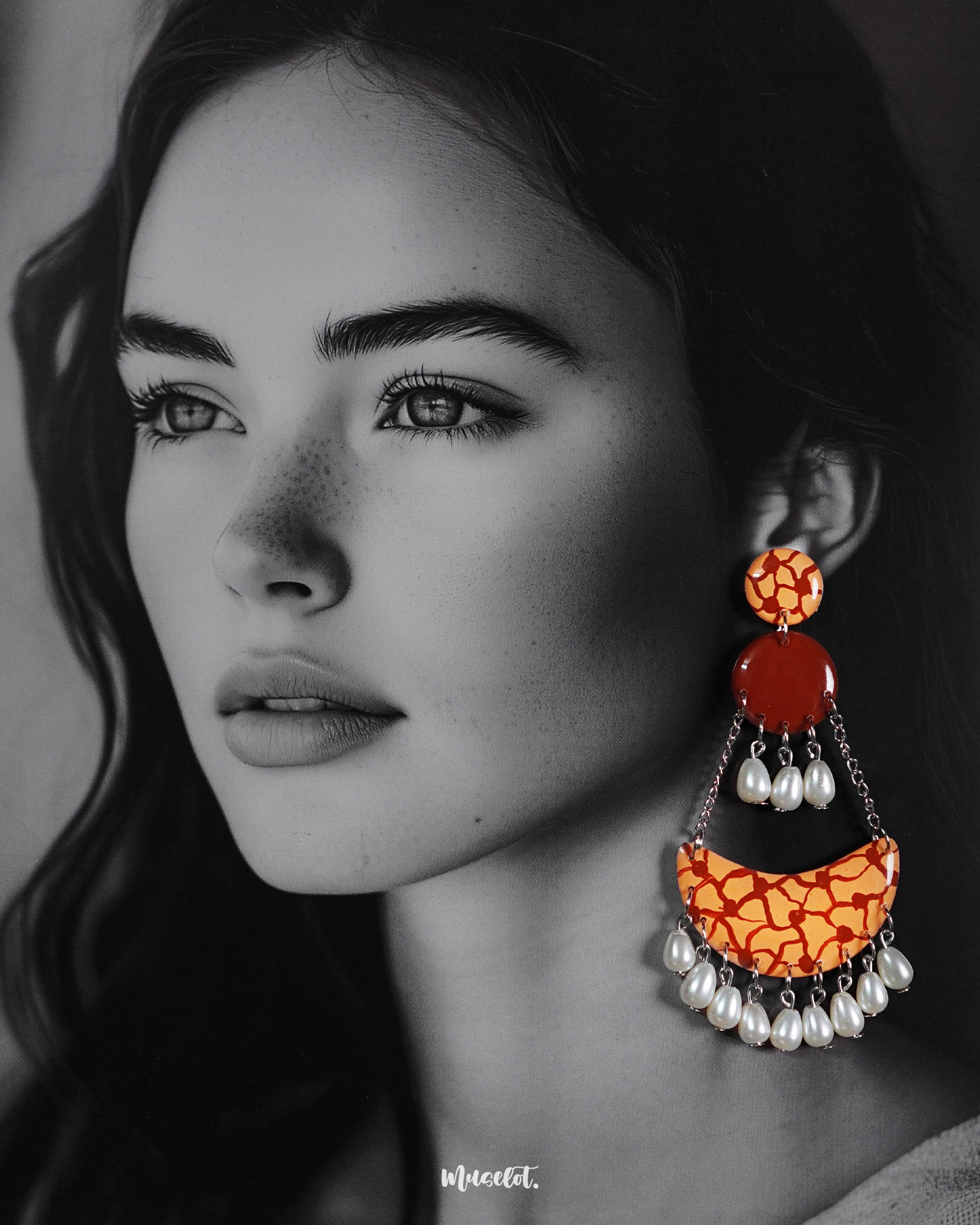 A model wearing the Mittika chandbali earrings, where warm terracotta hues and crackled orange textures blend beautifully with soft pearl droplets — offering an earthy, artistic charm that elevates any look — Muselot.