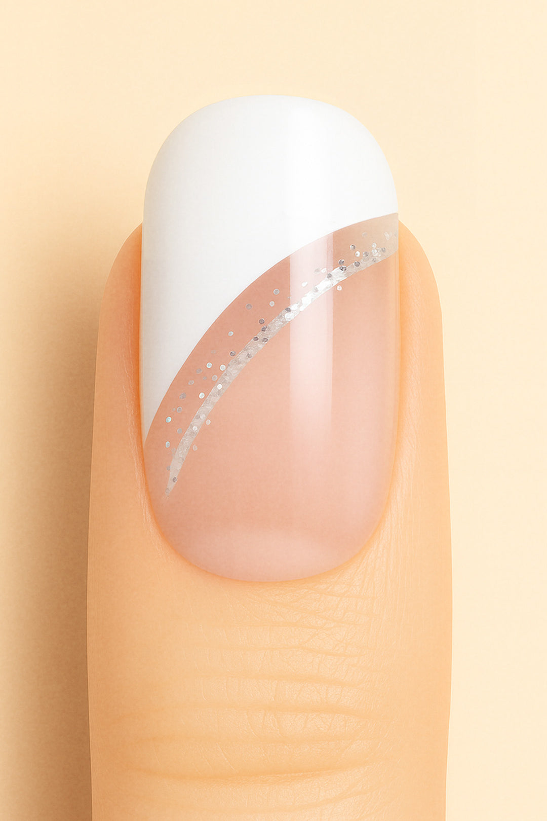 A close-up view of a single nail featuring the Moonlit Wave French Tip Nail Stickies design from Muselot. The nail has a crisp white diagonal French tip accentuated by a delicate silver glitter line, blending into a natural nude base. The glossy finish enhances the chic and modern look, perfect for elegant nail art styles.