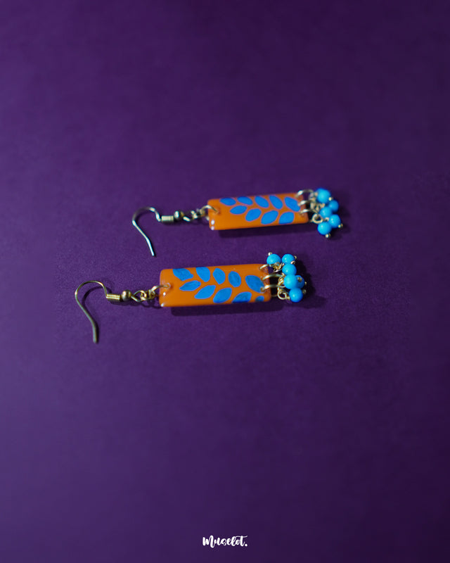 A  Narmshaam handmade hook earrings, focusing on the intricate threadwork and tiny bead accents that highlight the fine craftsmanship and playful boho vibe — Muselot.