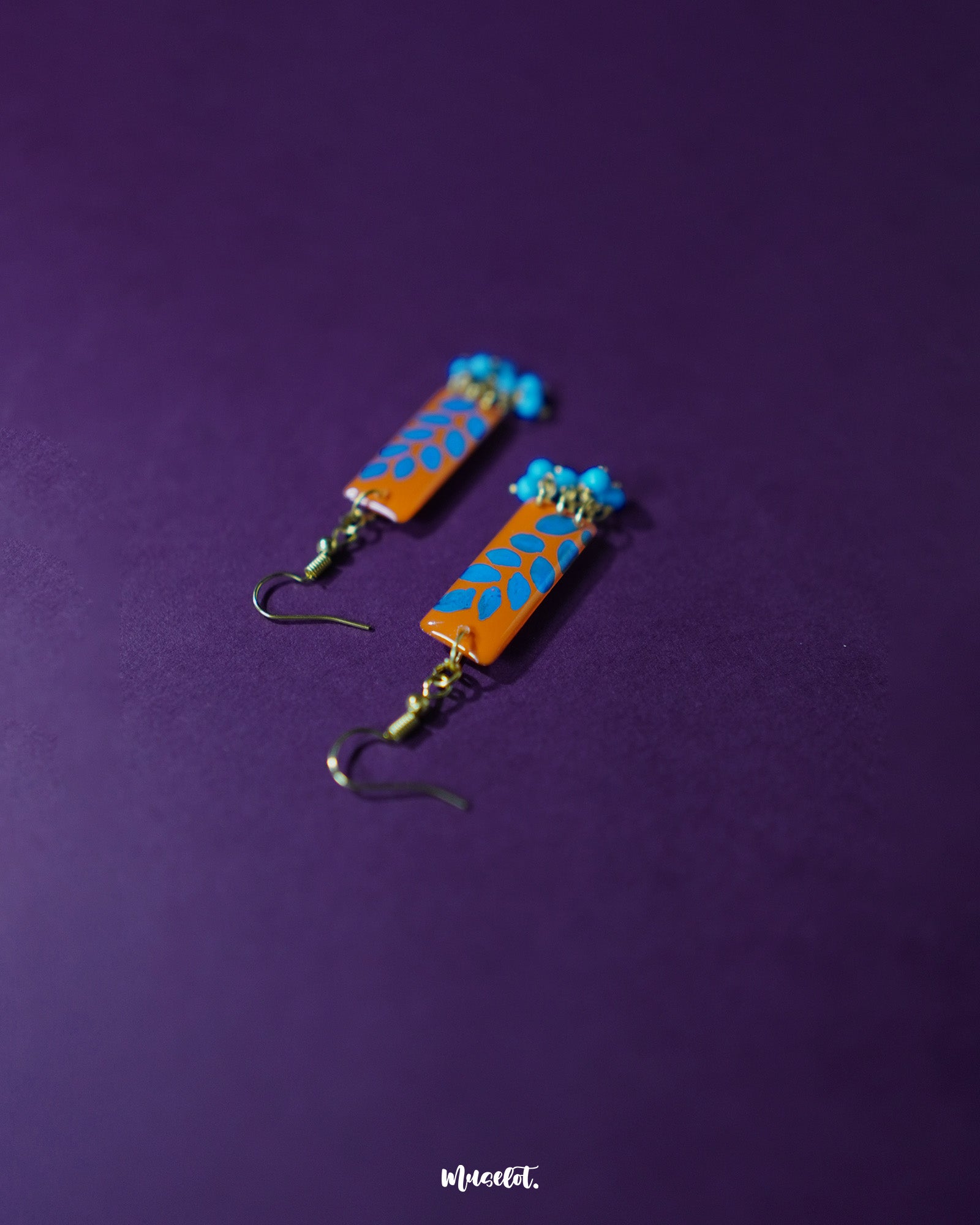 Narmshaam handmade hook earrings placed on a soft fabric, showcasing their delicate thread design, subtle color blend, and lightweight build perfect for adding an artsy charm to everyday looks — Muselot.