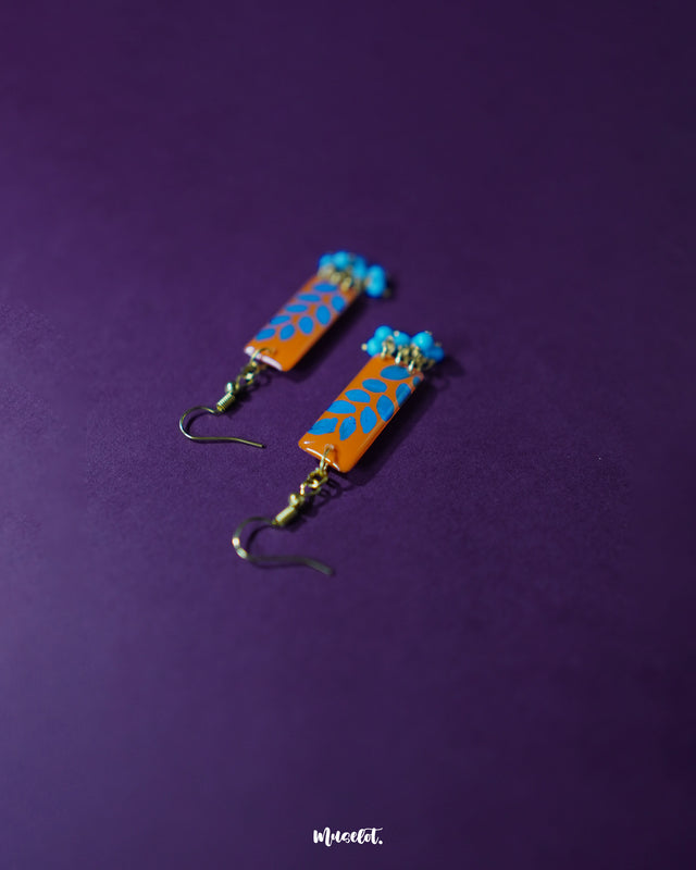 Narmshaam handmade hook earrings placed on a soft fabric, showcasing their delicate thread design, subtle color blend, and lightweight build perfect for adding an artsy charm to everyday looks — Muselot.