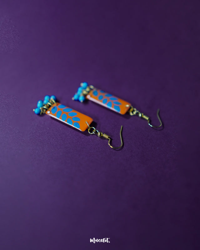 Narmshaam handmade hook earrings set against a purple background, highlighting their intricate threadwork, boho-inspired design, and soothing color palette that adds a soft, artistic touch to casual outfits — Muselot.