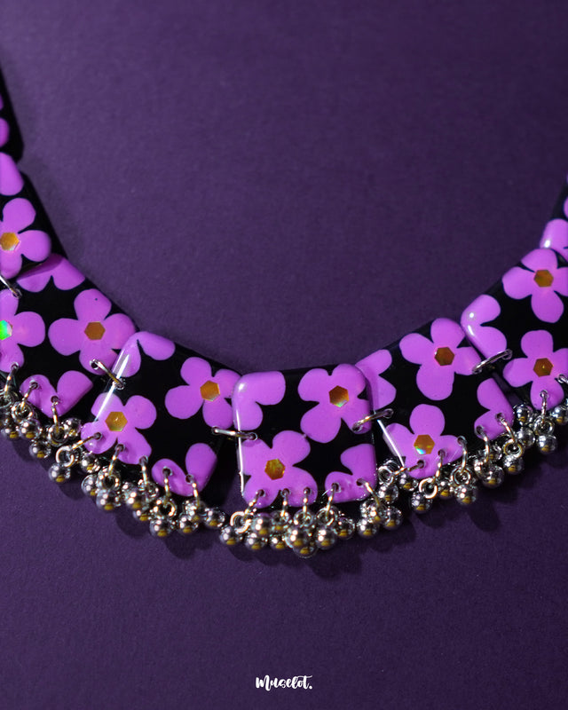 A stunning shot of the Naubahar handmade purple necklace set, placed against a rich purple background. The necklace features beautifully detailed lavender flowers, creating a harmonious and elegant look. The soft lavender shade of the flowers stands out against the deep purple background, adding a luxurious touch to the ensemble — Muselot