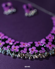 A captivating image of the Naubahar handmade purple necklace set, showcasing its intricate design with delicate lavender flowers. The rich tones of the purple in the necklace complement the floral details, creating an elegant and sophisticated aesthetic. The piece is styled to perfection, offering a harmonious balance of nature-inspired beauty and craftsmanship — Muselot
