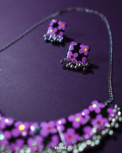 A closer look at the Naubahar handmade purple necklace set, highlighting its exquisite lavender floral embellishments. The set is designed with elegance in mind, featuring soft purple hues that flow gracefully through the delicate petals. Its intricate details and refined craftsmanship make it a perfect accessory for adding a touch of nature-inspired beauty to any ensemble — Muselot