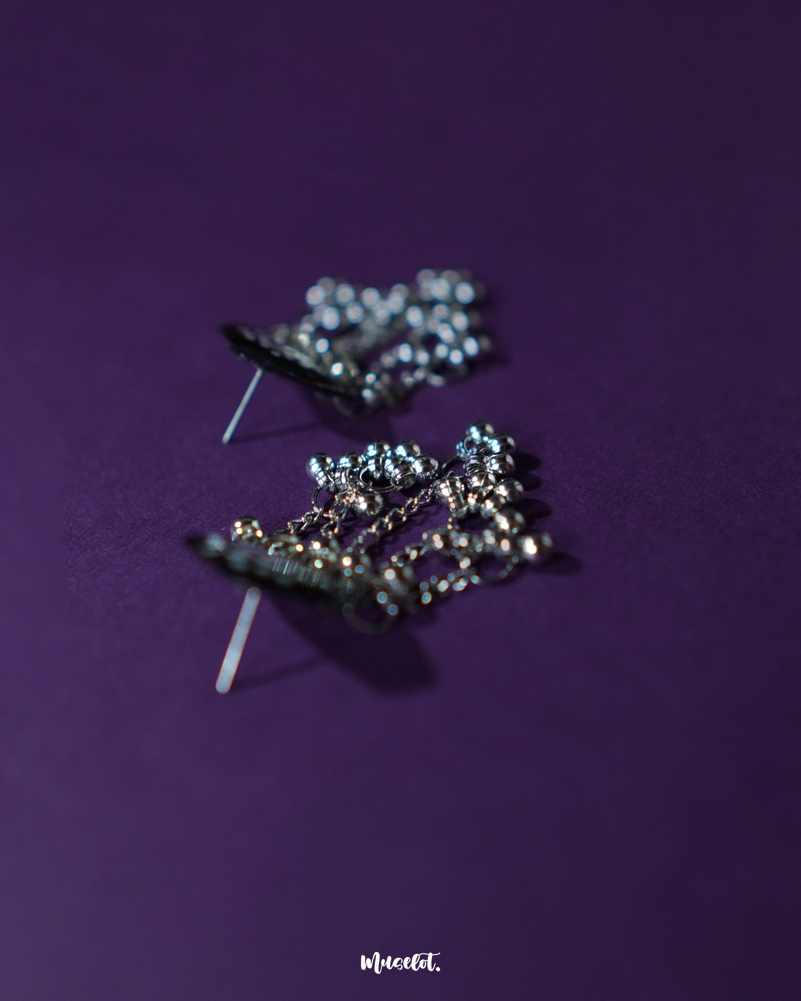 Nazafar black jhumkas displayed on a plain backdrop, showcasing striking white circular patterns while highlighting the oxidized silver dome and bold ethnic appeal – Muselot.