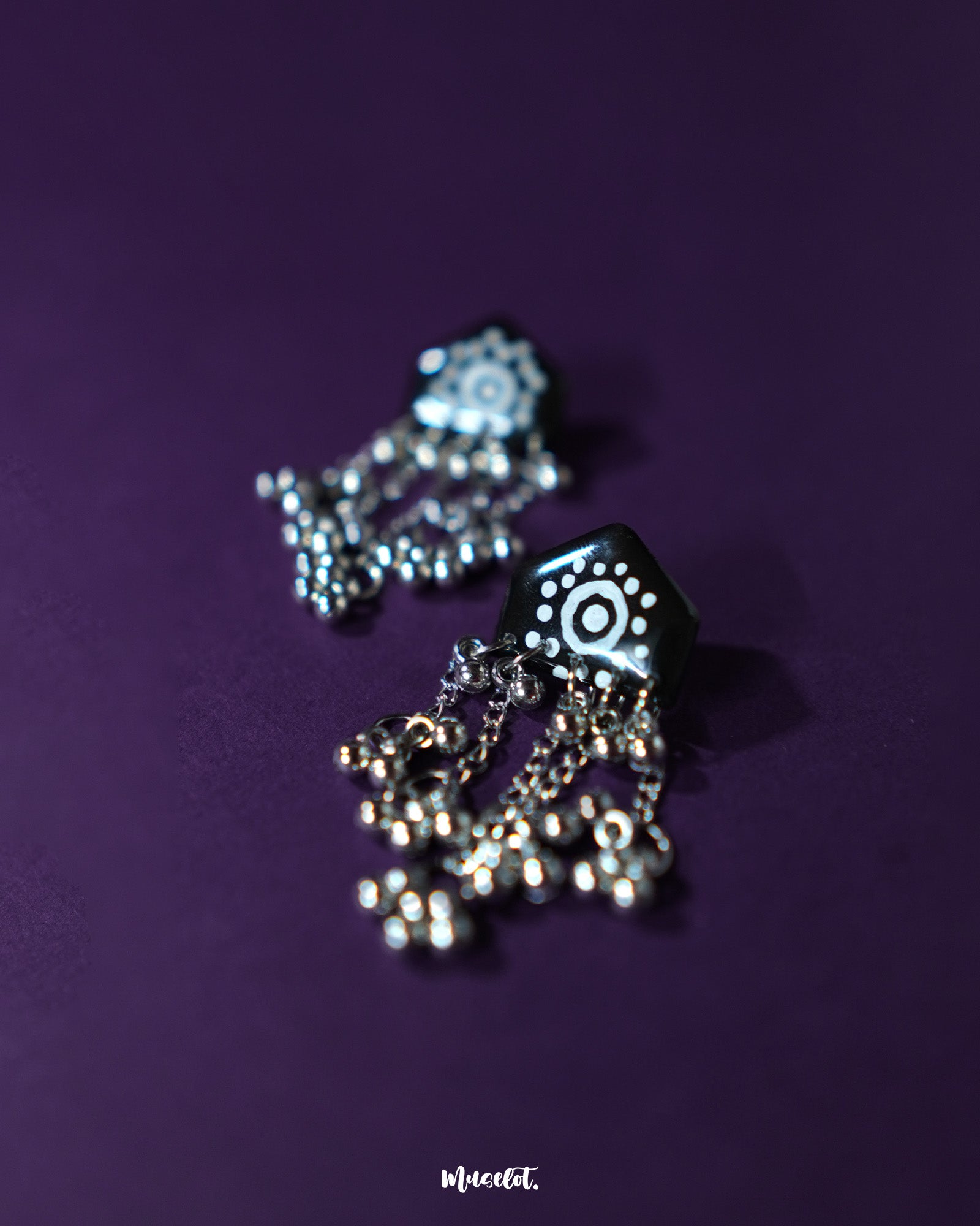 Front view of Nazafar black jhumkas, showcasing the vivid white motif accents while highlighting the traditional silver dome and handcrafted elegance – Muselot.