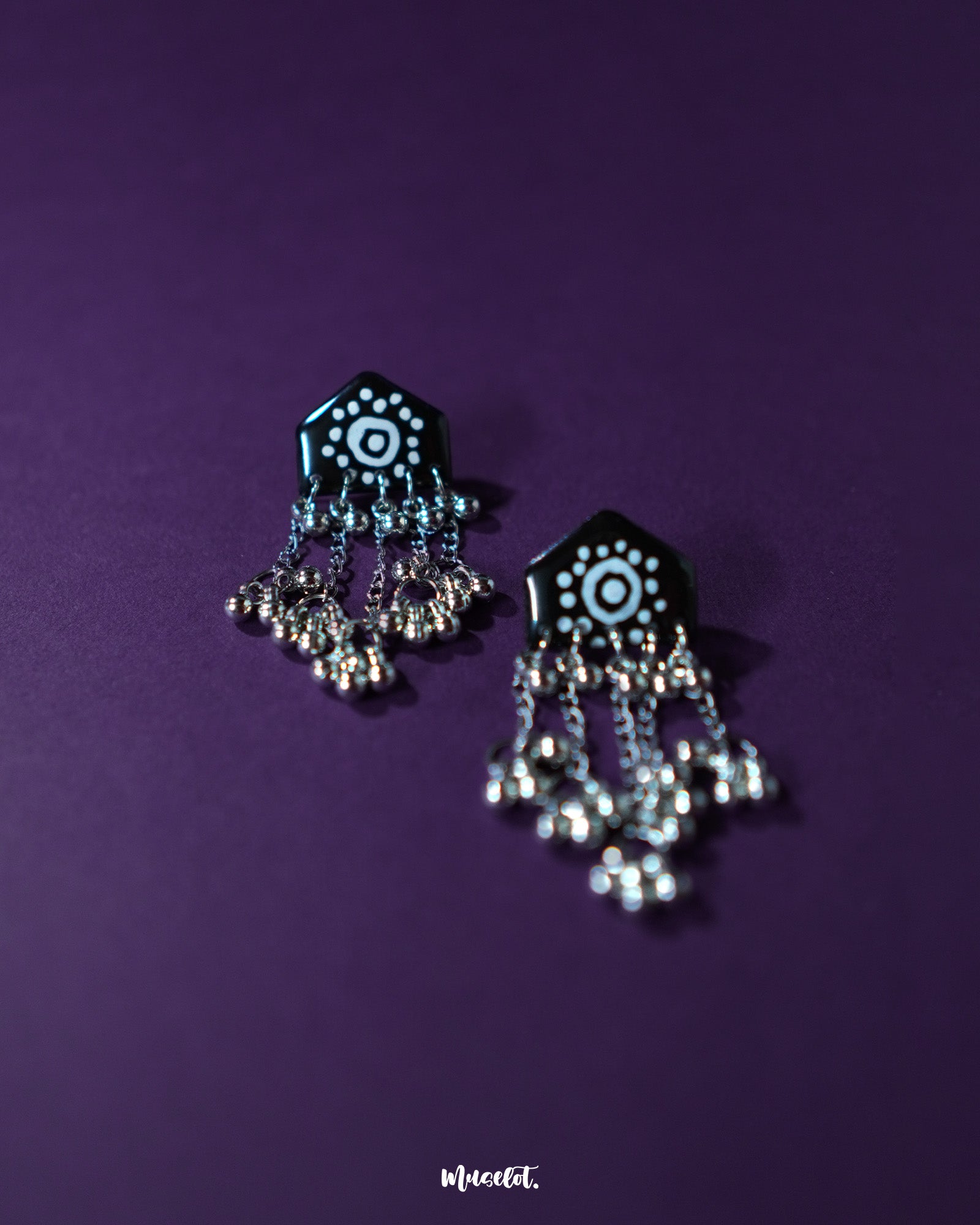 Nazafar black jhumkas in a close-up view, showcasing detailed white circular artwork while highlighting the antique silver dome and traditional craftsmanship – Muselot.