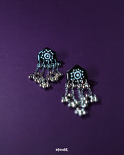 Nazafar black jhumkas in a close-up view, showcasing detailed white circular artwork while highlighting the antique silver dome and traditional craftsmanship – Muselot.