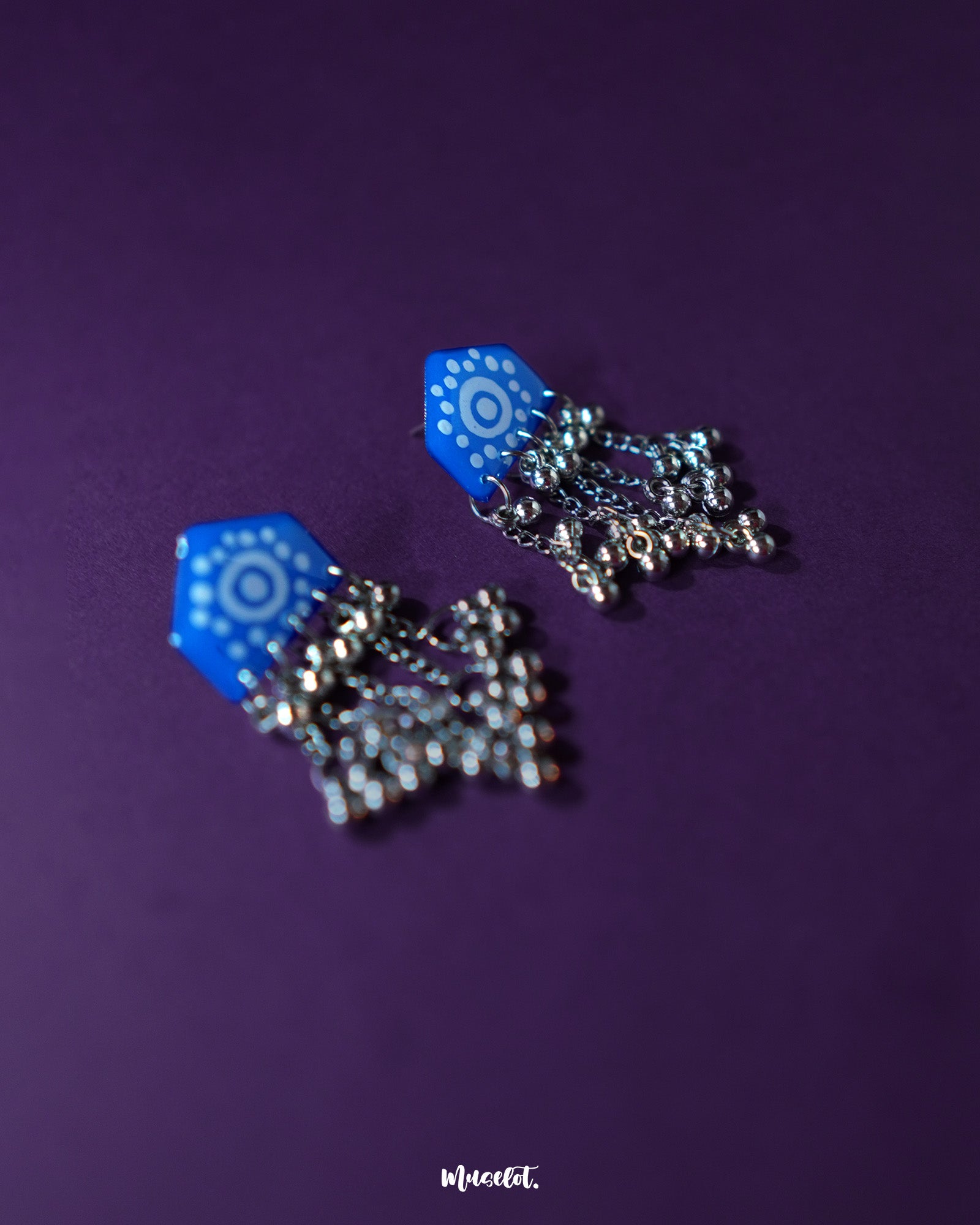 Nazafar blue jhumkas captured in a close view, showcasing intricate white motif detailing while highlighting the oxidized silver dome and ethnic artistry – Muselot.