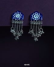 Nazafar dark blue handcrafted earrings with white circular motifs and cascading silver ghungroo chains, displayed against a simple backdrop – Muselot.