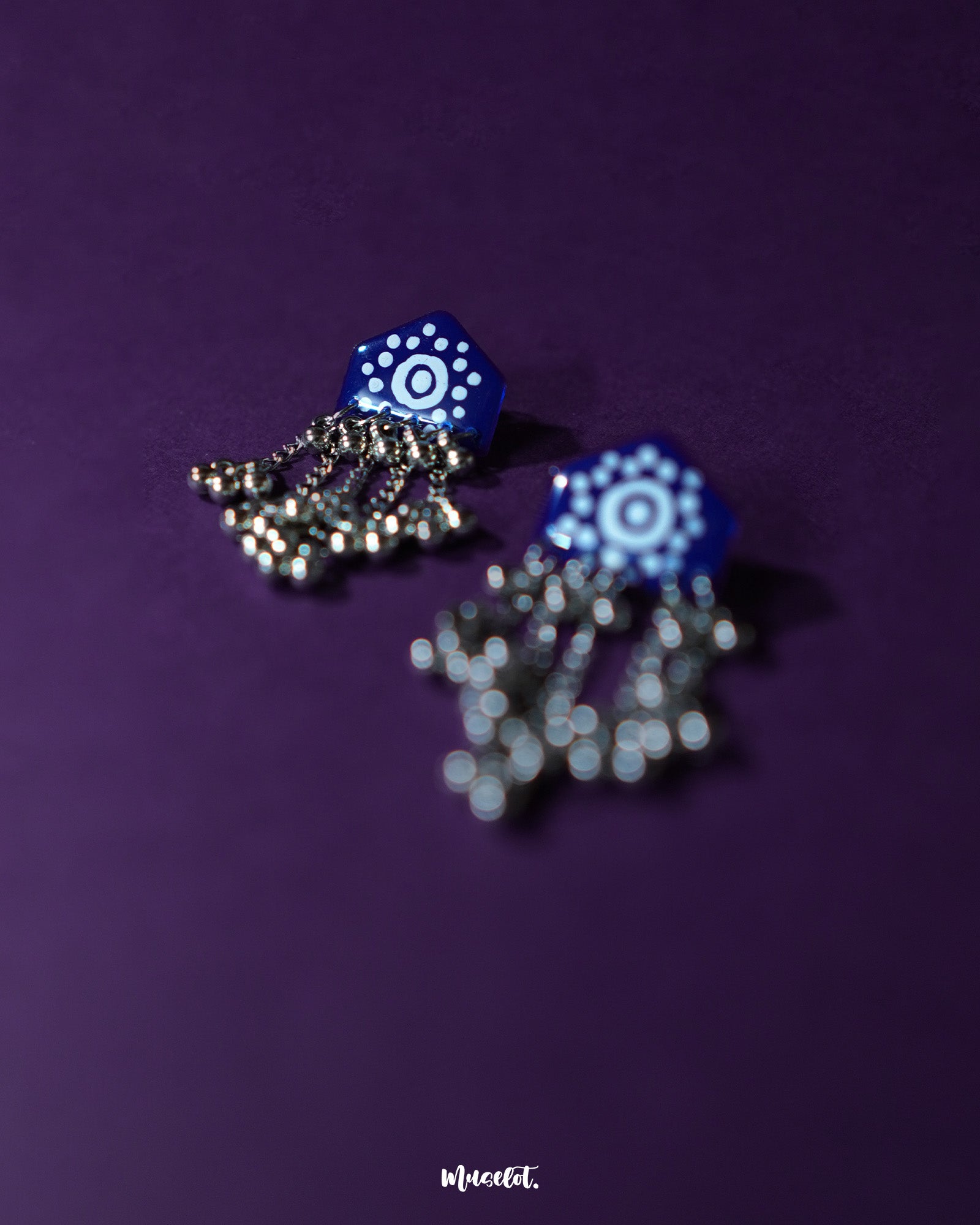 Nazafar dark blue jhumkas captured at an angle, showcasing the hand-painted white detailing while highlighting the oxidized silver dome and artisanal craftsmanship – Muselot.