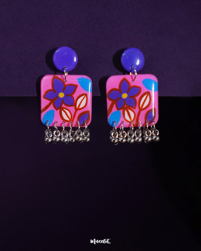 Nazmira boho floral stud earrings, set against a deep hue backdrop, with delicate floral patterns and earthy tones that enhance their vintage-inspired, bohemian elegance — Muselot.