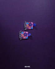 Nazmira handmade floral stud drop earrings, elegantly displayed against a rich purple background, with delicate floral details and a soft drop design that exude bohemian charm and sophistication — Muselot.
