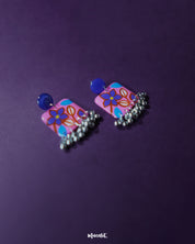 Nazmira handmade floral stud drop earrings, framed by a rich purple background, showcasing delicate floral details and an elegant drop design that bring out their boho-inspired charm — Muselot.