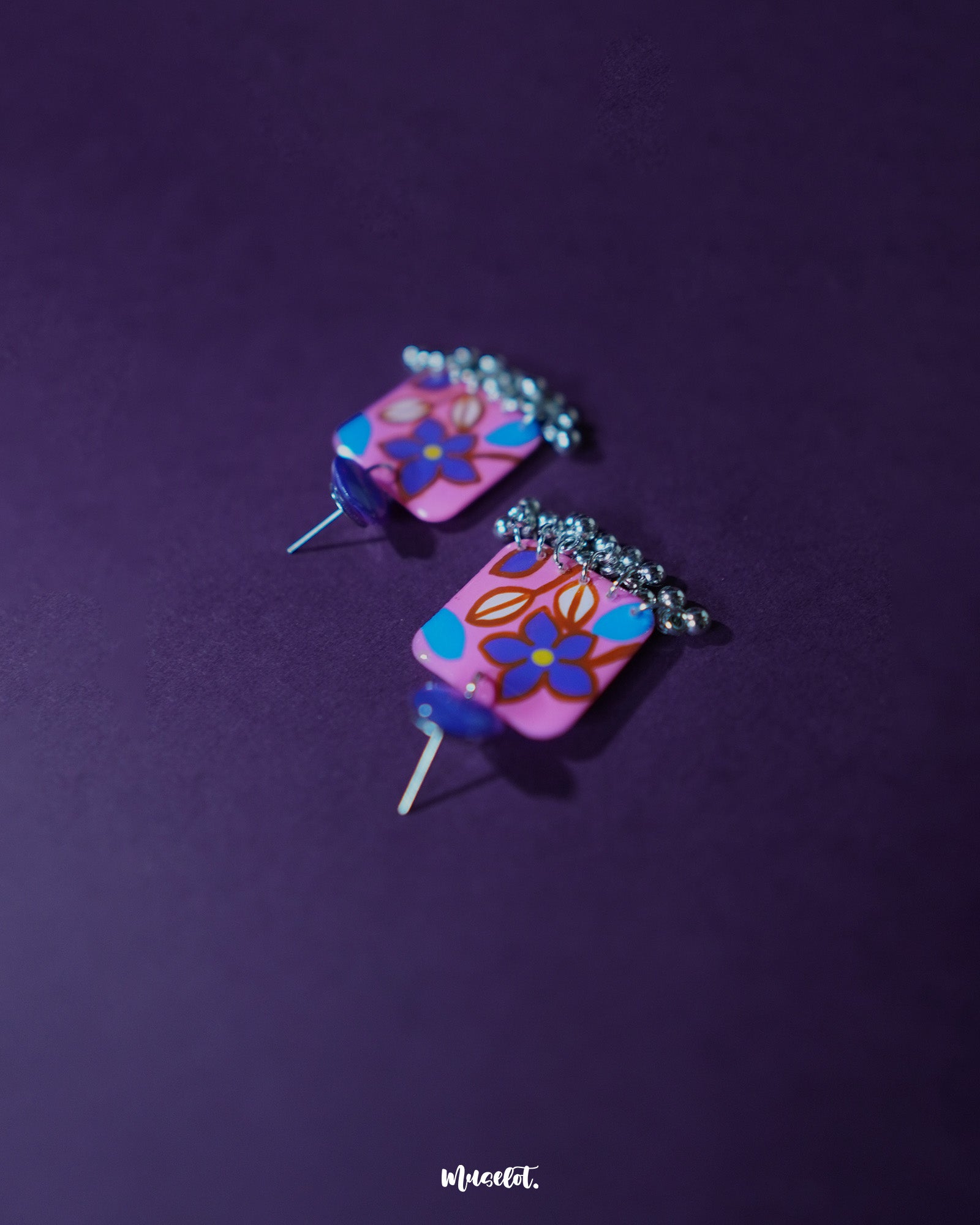 Nazmira handmade floral stud drop earrings, set against a bold purple background, with intricate floral patterns and a delicate drop design that exude a perfect blend of bohemian flair and timeless elegance — Muselot.