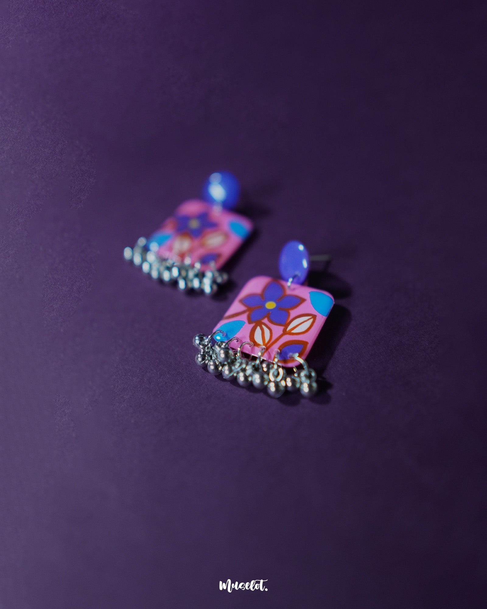 Nazmira handmade floral stud drop earrings, placed against a deep purple background, featuring finely detailed floral studs and an elegant drop that adds a sophisticated boho touch to any outfit — Muselot.