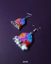 Angle view of Nazrana multicolour floral earrings, highlighting the hand-painted motifs and silver ghungroo detailing on a clean backdrop – Muselot.