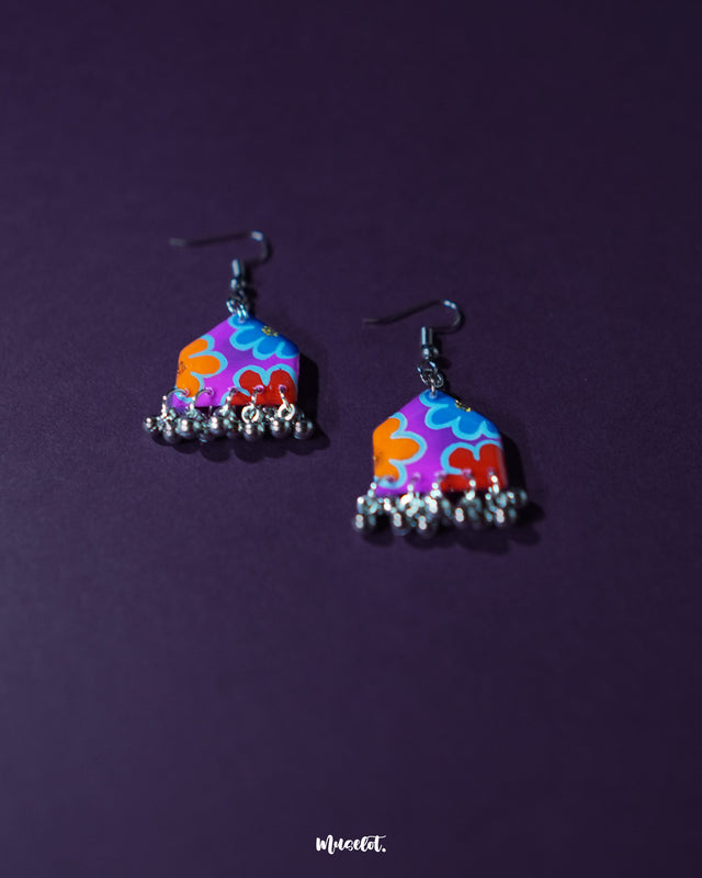 Close-up of Nazrana multicolour floral earrings, showcasing intricate hand-painted design with vibrant hues and silver ghungroo drops against a plain background – Muselot.