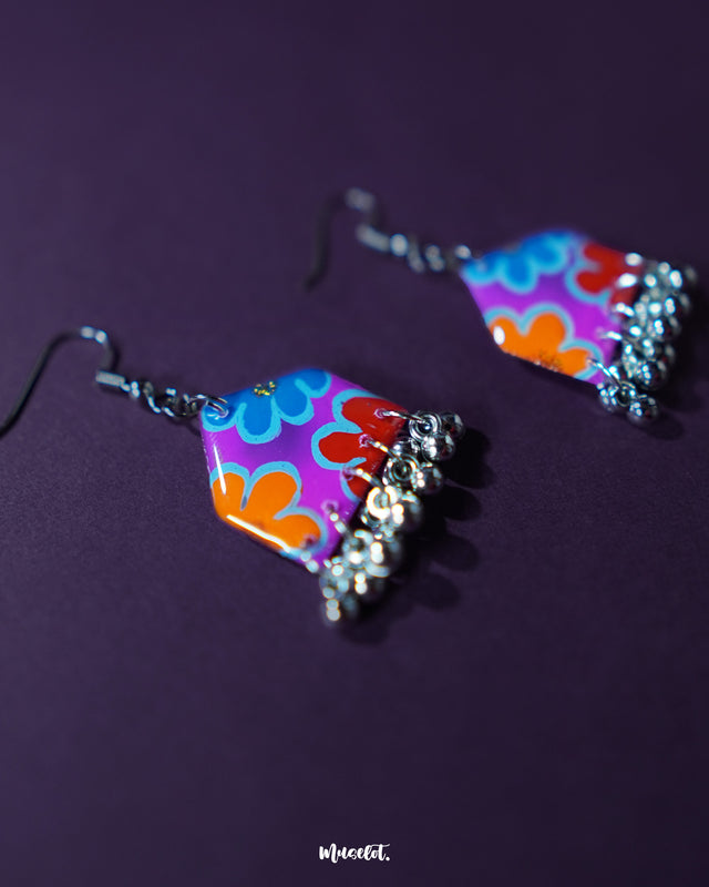 Front display of Nazrana multicolour floral earrings, highlighting the vibrant hand-painted patterns and silver ghungroo accents against a plain background – Muselot.