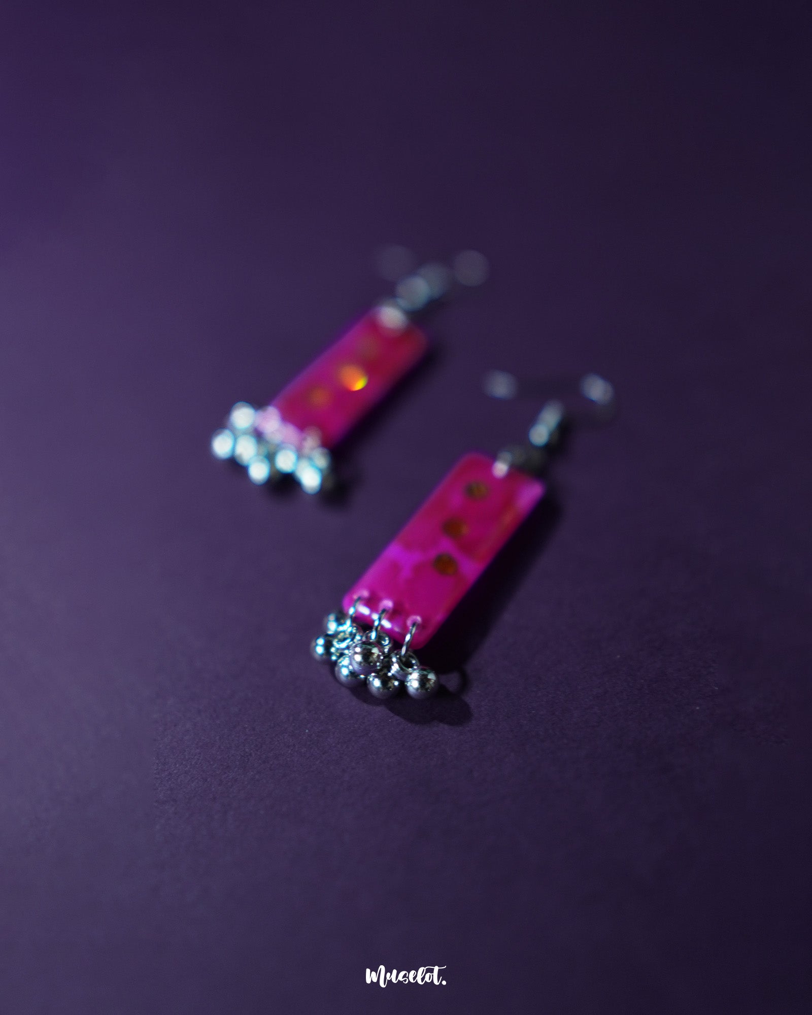 Noorasa drop earrings against a rich purple background, enhancing their elegant design – Muselot